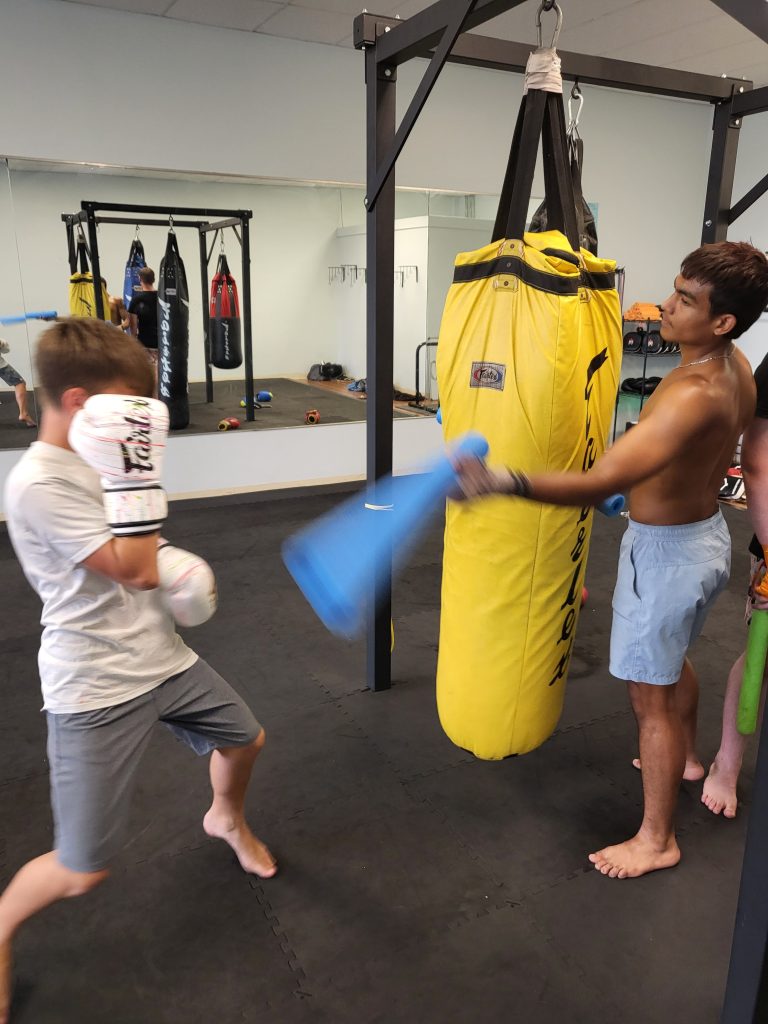 Students training around the heavy bags at 81's Fight Club.