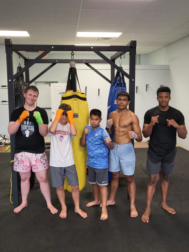Members of 81's Fight Club posing together on the gym floor.