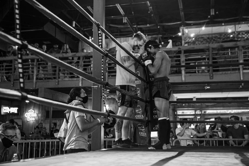 Coach speaking to a fighter in the ring between rounds.